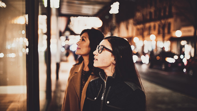 Young woman and mother window shopping during holidays