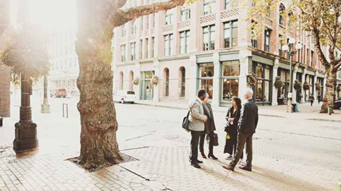 Business colleagues in discussion on city street during morning commute