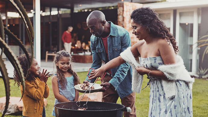 Family cooking on grill in their garden
