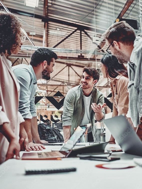 Casually dressed colleagues having a meeting at  table in warehouse