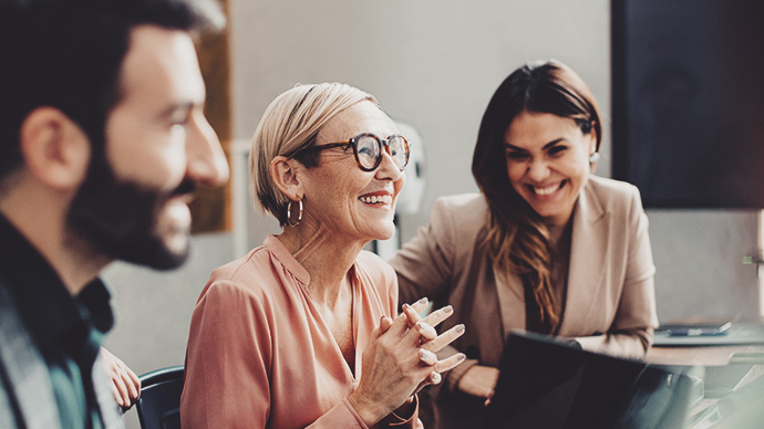 Happy business people discussing during meeting in board room at corporate office